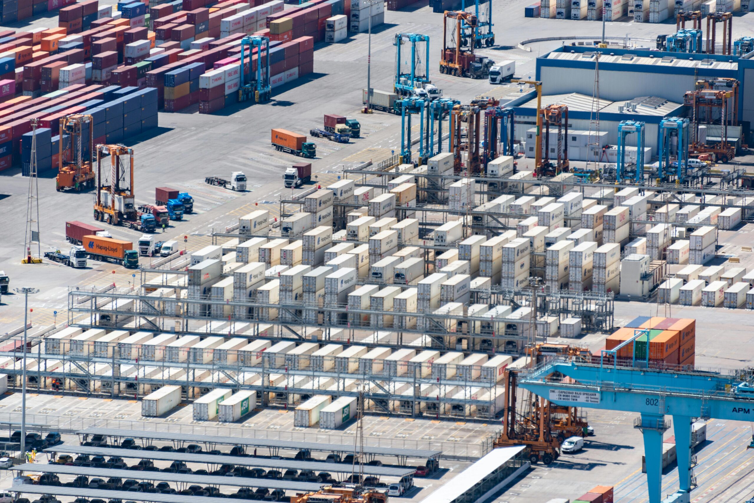An aerial image showcasing a bustling cargo port with stacked containers and logistics machinery.